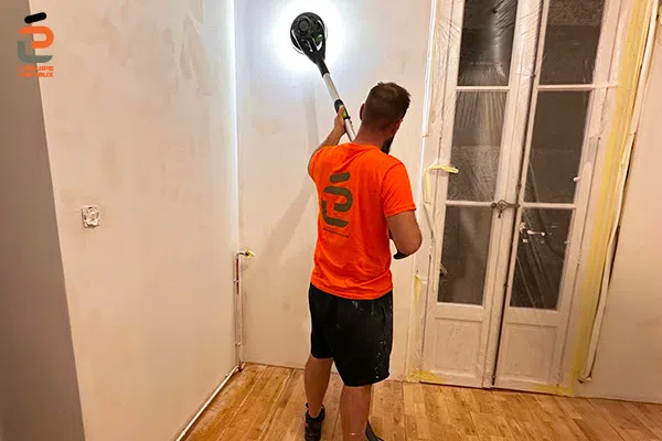 Ponçage de mur dans le cadre de rénovation de peintures