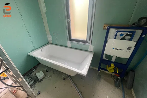 Pose d'une baignoire et d'un bati-support de chasse d'eau encastrée pour cuvette wc suspendue dans la salle de bain d'une villa à Mus
