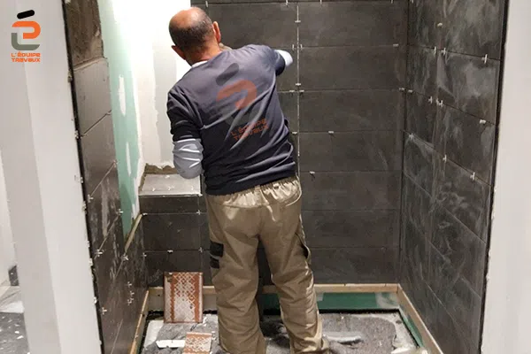 Pose de faïences dans une salle de douche neuve pour un appartement à la Grande Motte
